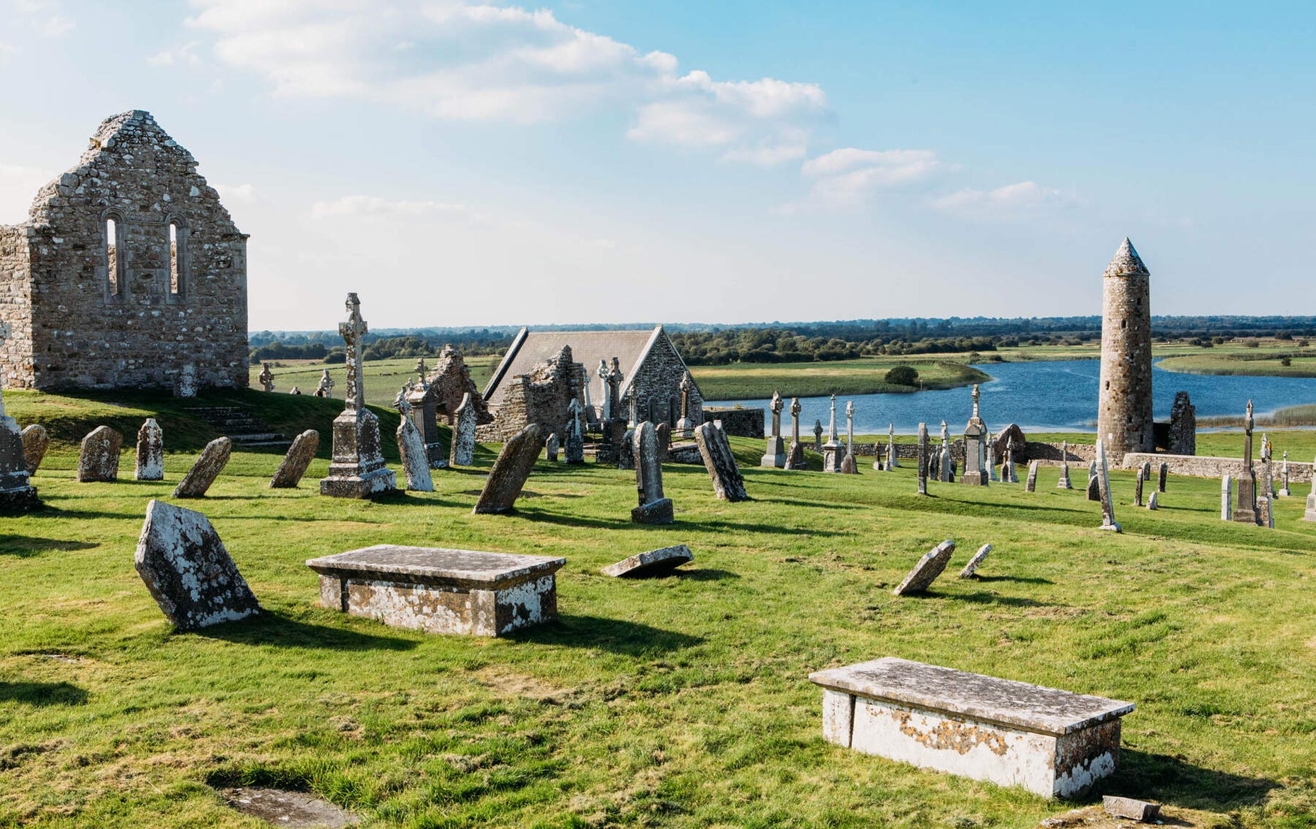 Ancient ruins and round tower at Clonmacnoise Monastery beside the River Shannon in County Offaly, Ireland.