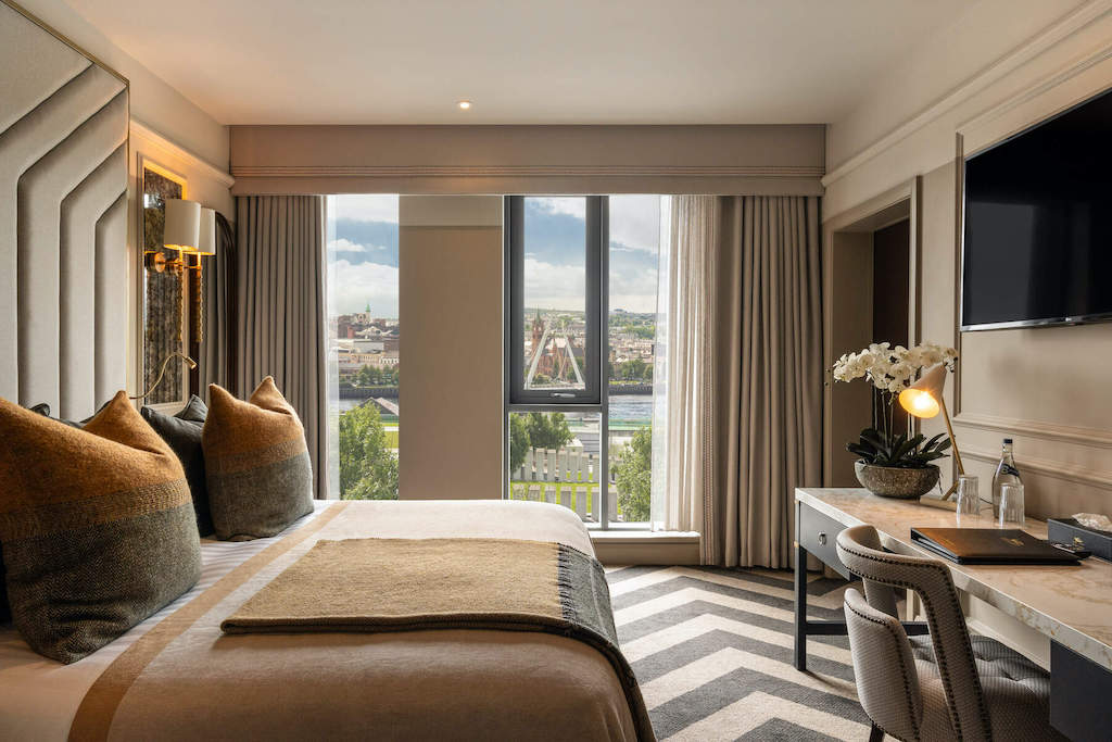 Habitación de hotel elegante con vistas al puente de la paz y al horizonte de la ciudad al otro lado del río Foyle en Derry~Londonderry.