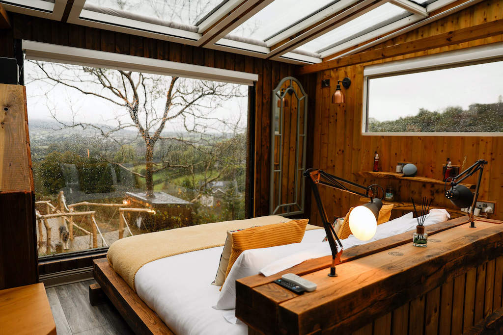 Ventanas salpicadas de lluvia en una acogedora cabaña de madera con vistas a una colina boscosa en el condado de Armagh.