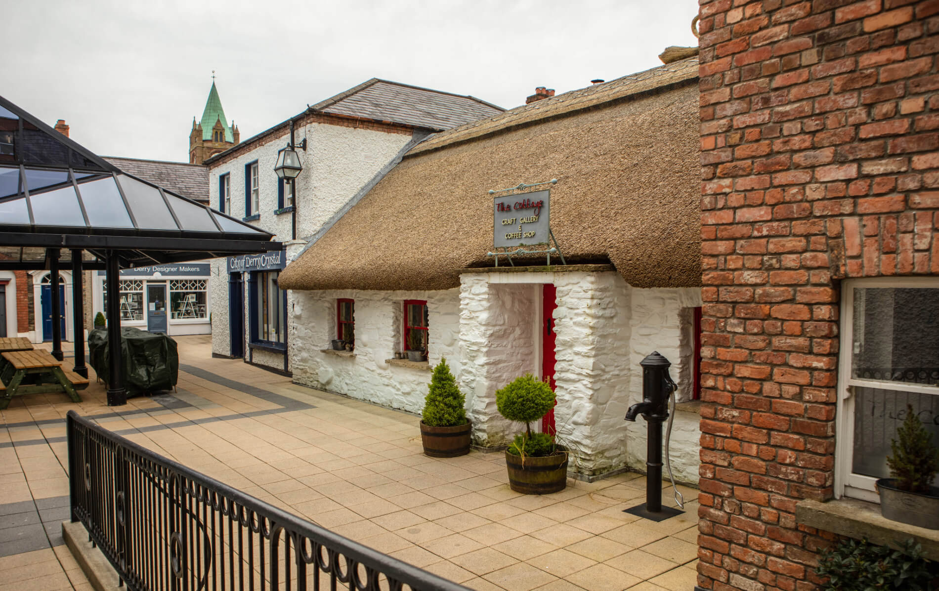 Thatched whitewashed cottage with red door housing a craft gallery and coffee shop in Derry~Londonderry.