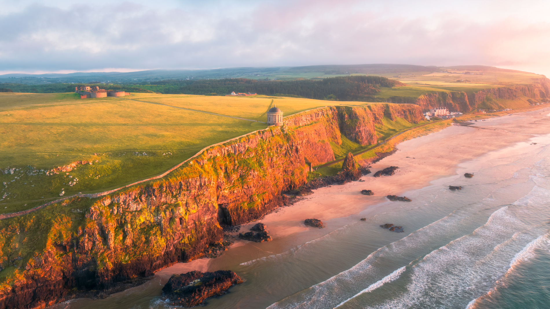 Mussenden Temple, gelegen op een klif boven het strand van Downhill, met uitzicht op de Atlantische kustlijn bij zonsondergang.