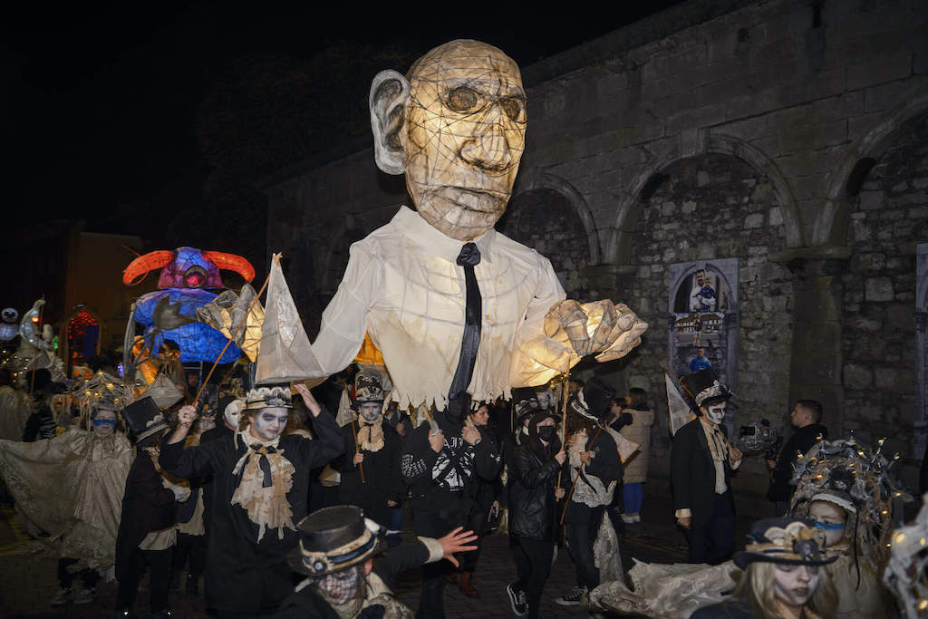 Street performers and parade floats go by at the Samhain Festival in Limerick city.