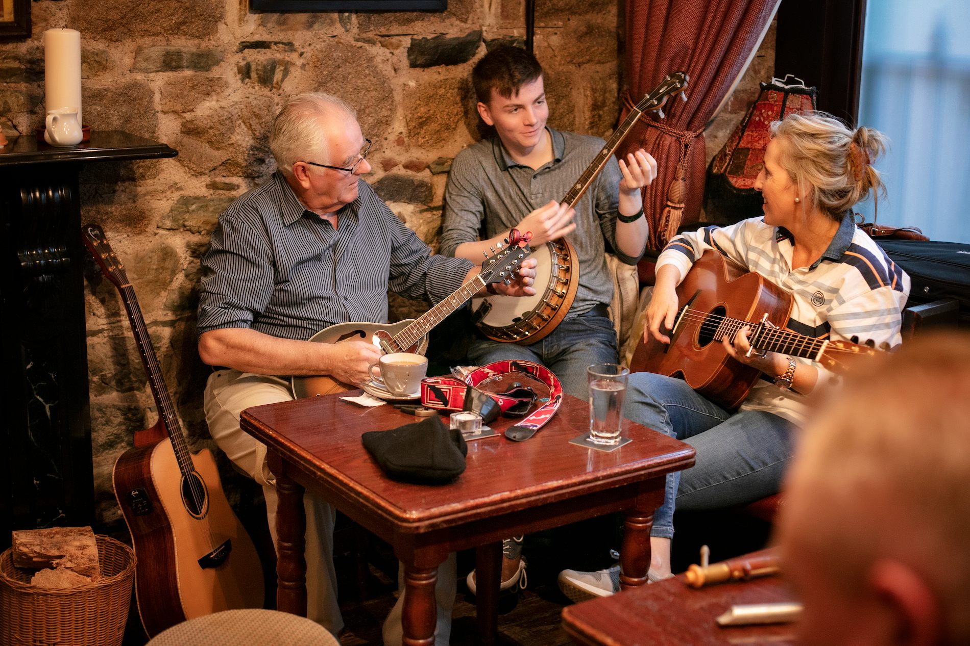 Musicians playing banjo, mandolin and guitar during a traditional music session in The Rostrevor Inn, County Down.