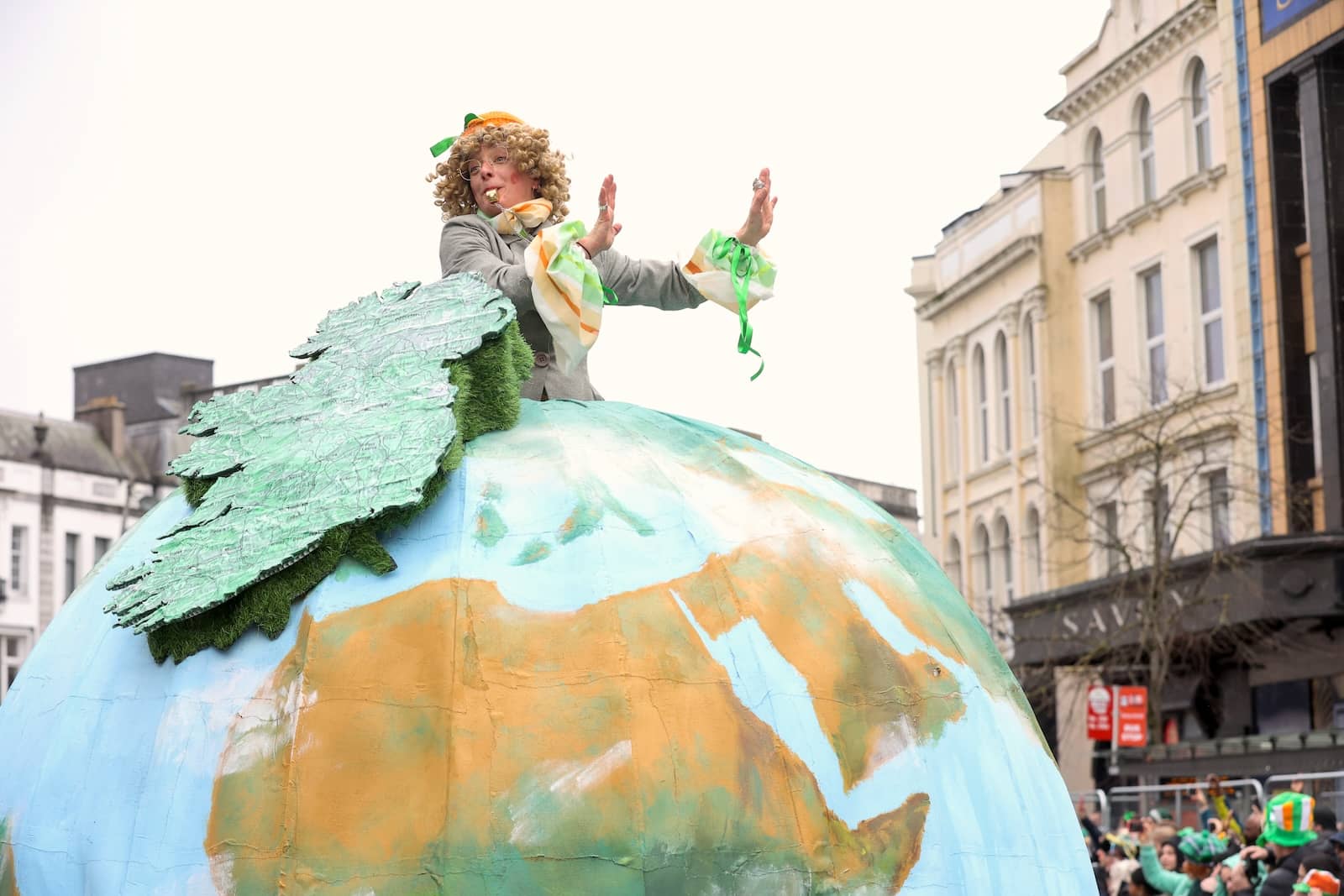 Costumed performer atop globe float during Cork’s lively St Patrick’s Day festivities.