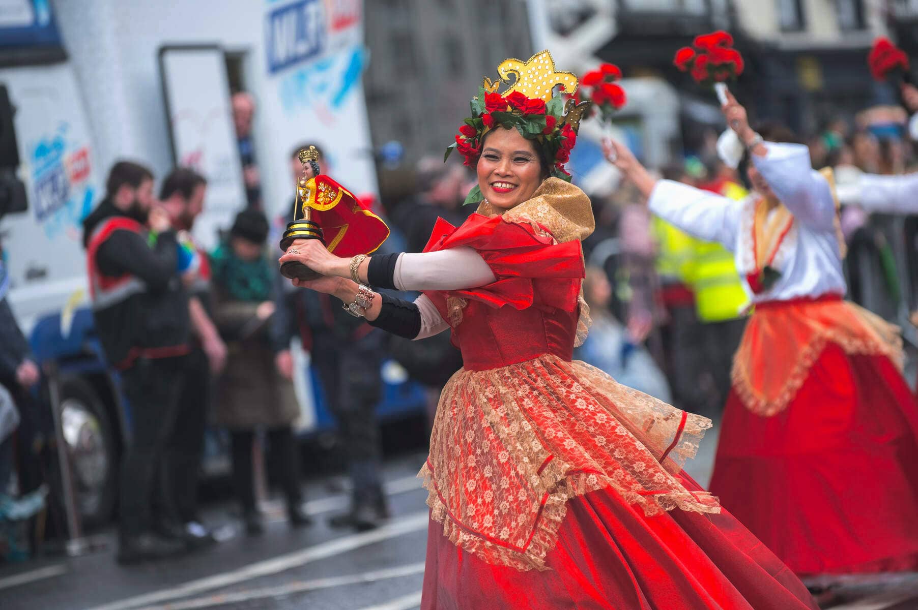 Une danseuse vêtue d'une robe rouge avec des fleurs dans les cheveux se produit lors d'un défilé de la Saint Patrick à Waterford.