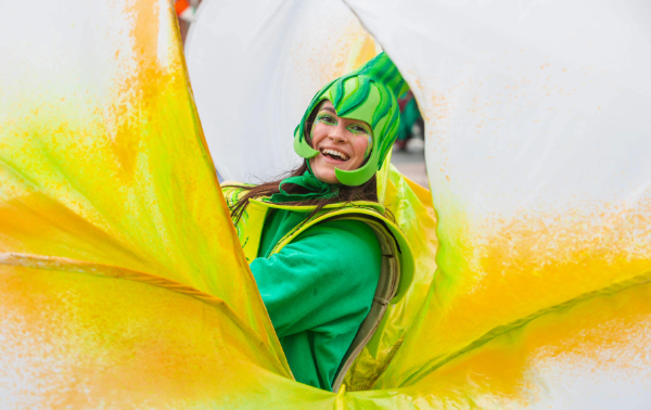 Un artiste souriant en costume vert et coiffe pose lors d'un défilé de la Saint Patrick à Limerick.