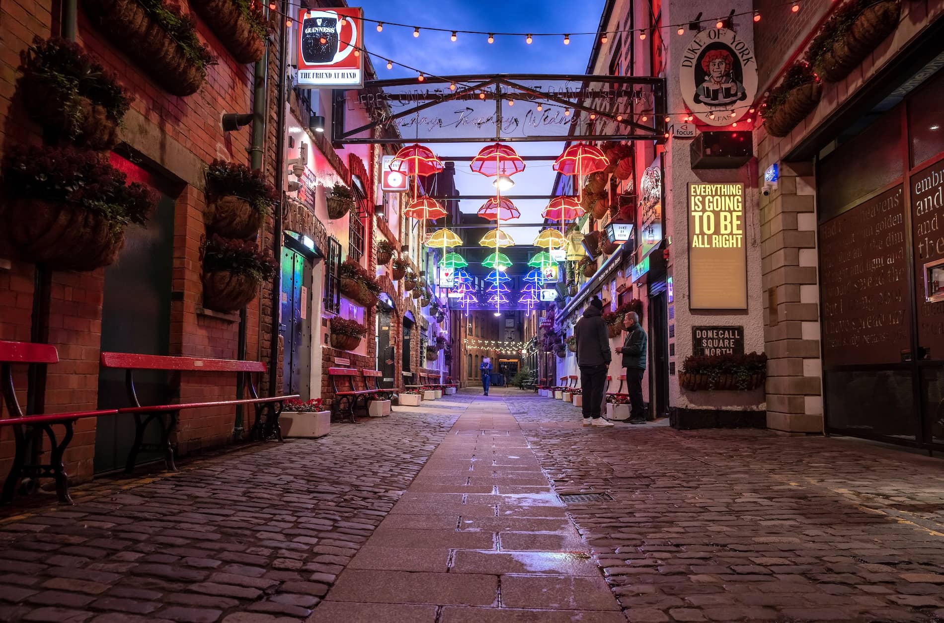Colourful umbrella lights illuminate Commercial Court in Belfast’s Cathedral Quarter, a popular nightlife and pub district.