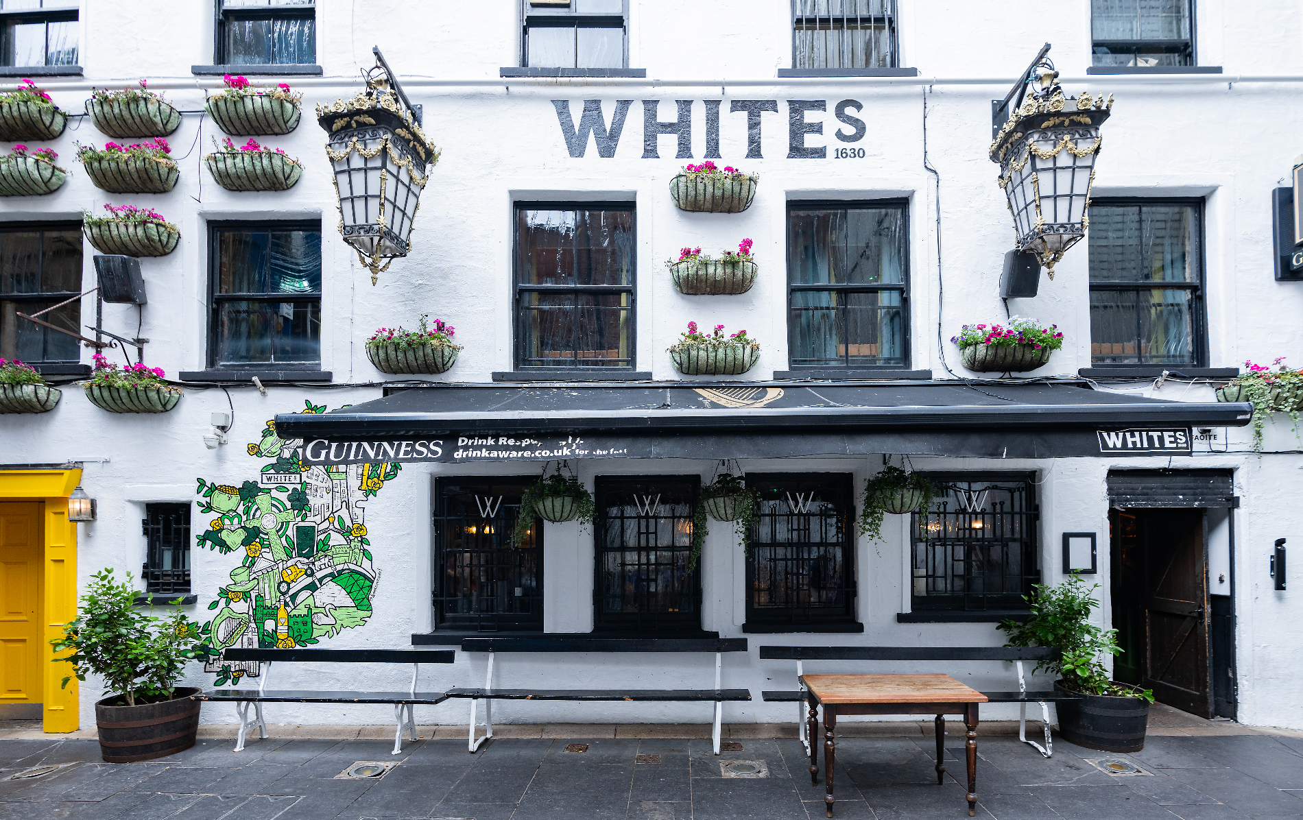 White’s Tavern in Belfast, with its white façade, hanging flower baskets and traditional pub frontage.