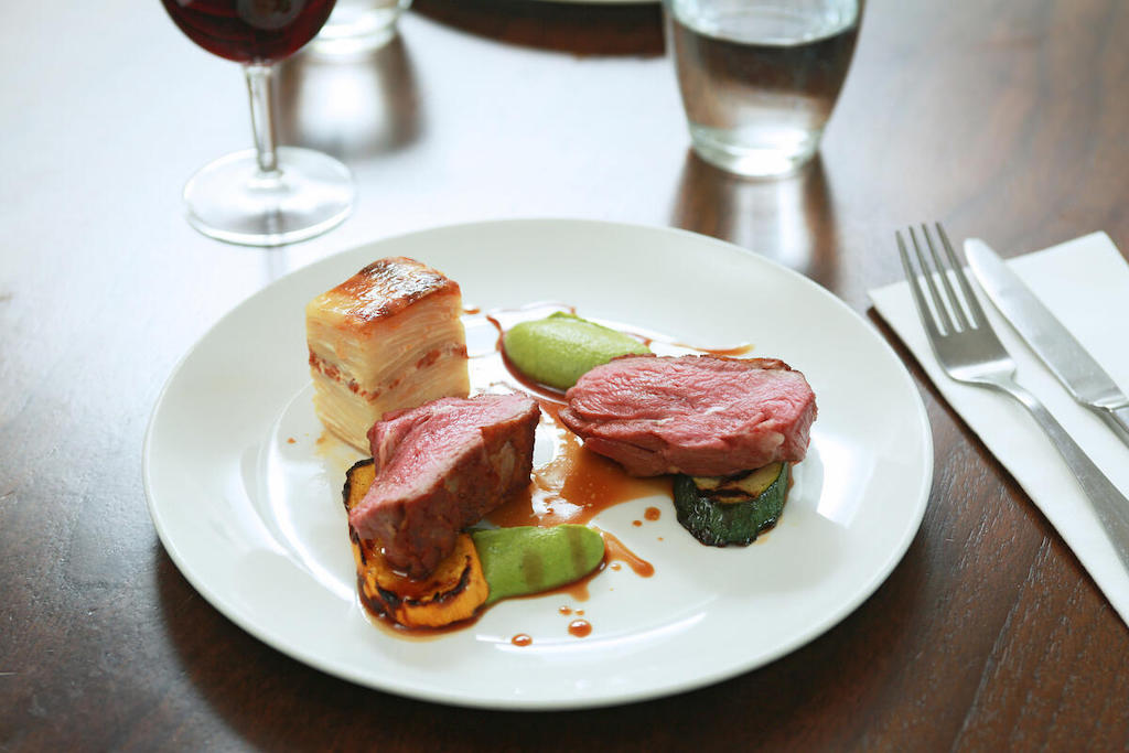 Rare beef with potato gratin, grilled vegetables, green purée and jus at James St restaurant in Belfast.