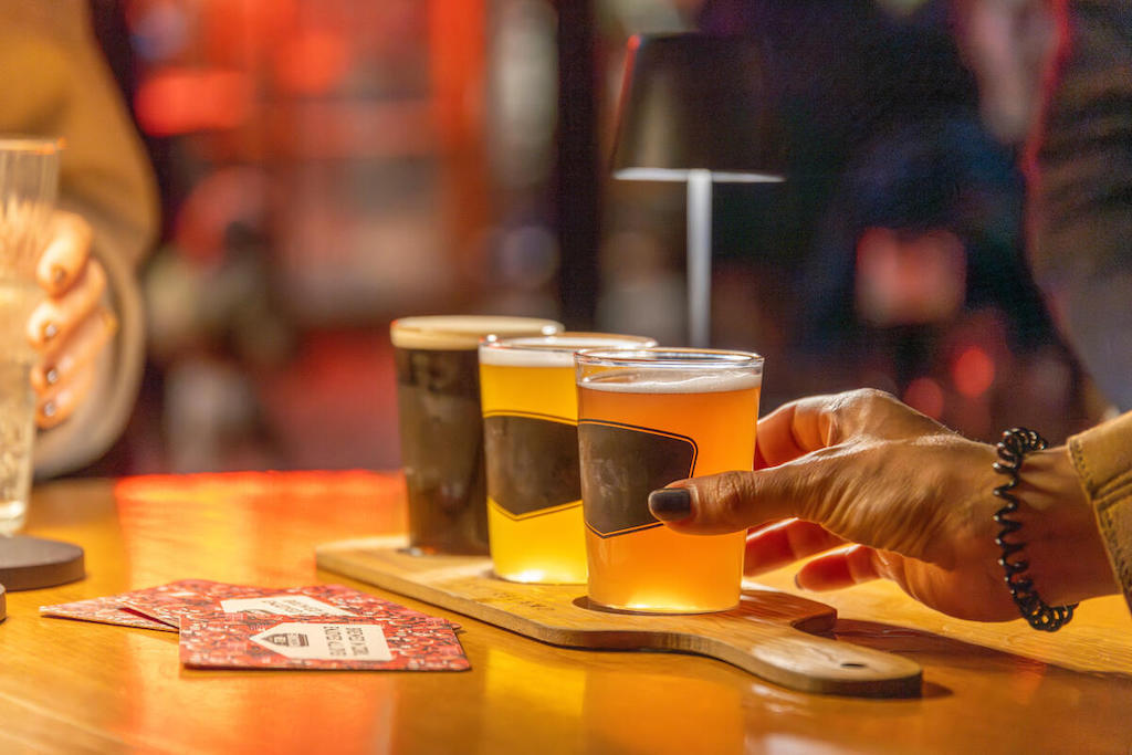 A hand lifts a glass from a beer tasting flight at the Franciscan Well brewery in Cork city.
