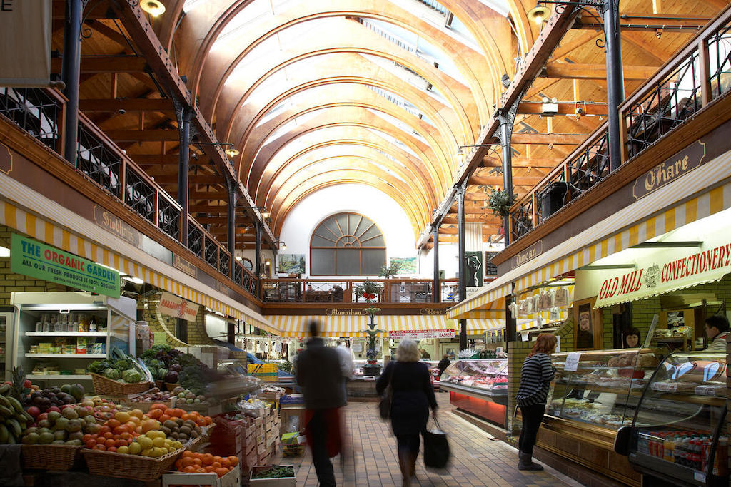 Shoppers browse fruit, vegetables, meat and other produce beneath the vaulted roof of the English Market in Cork City.