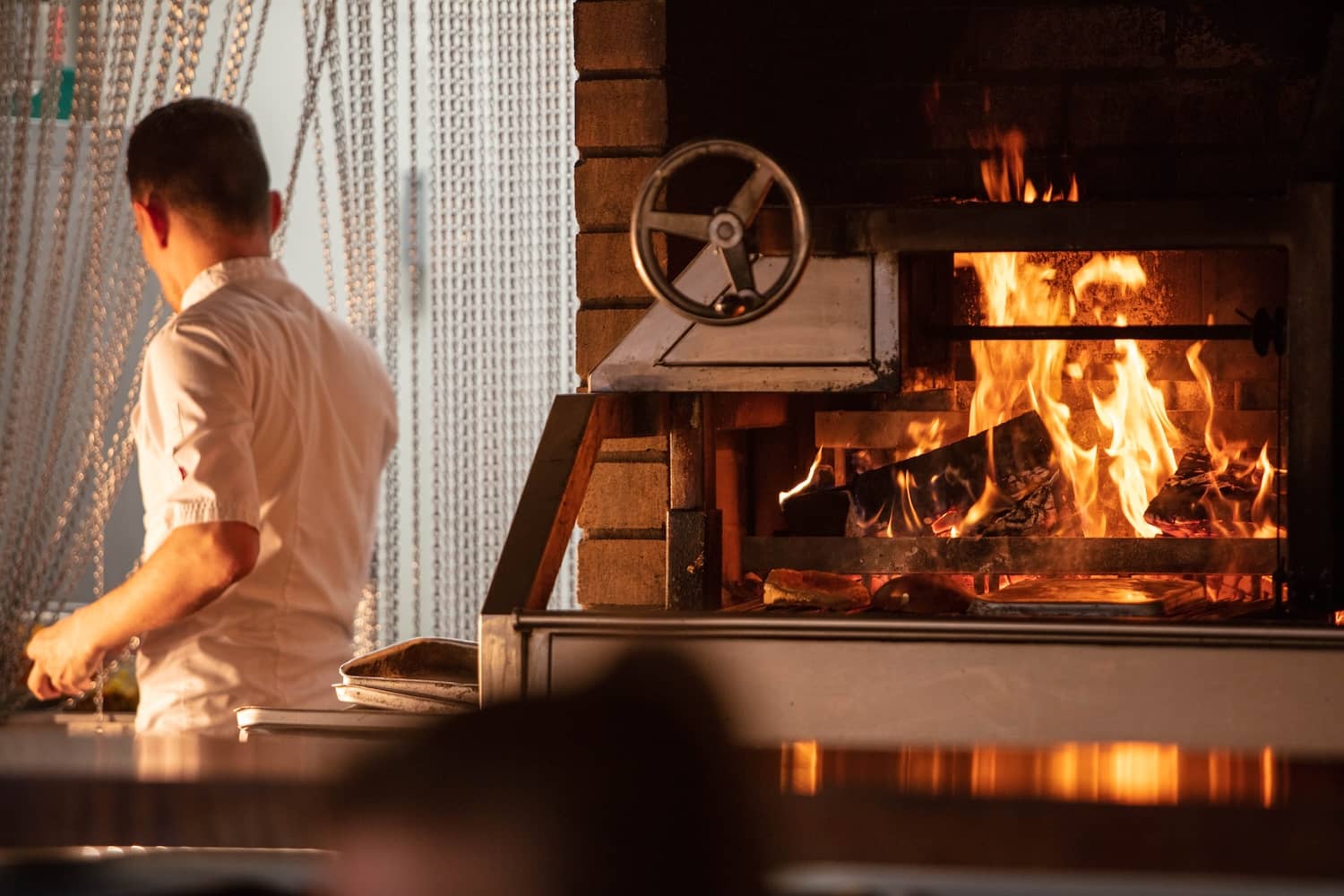 Chef cooking over an open fire during a food experience in Belfast, Northern Ireland.