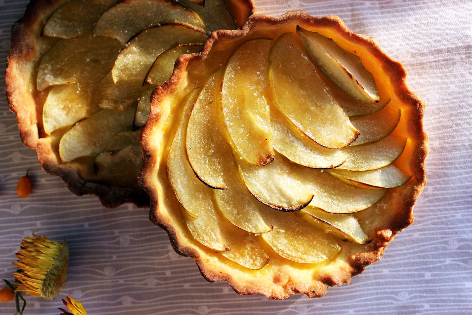 Golden apple tartlets with thinly sliced apples baked in crisp pastry shells.