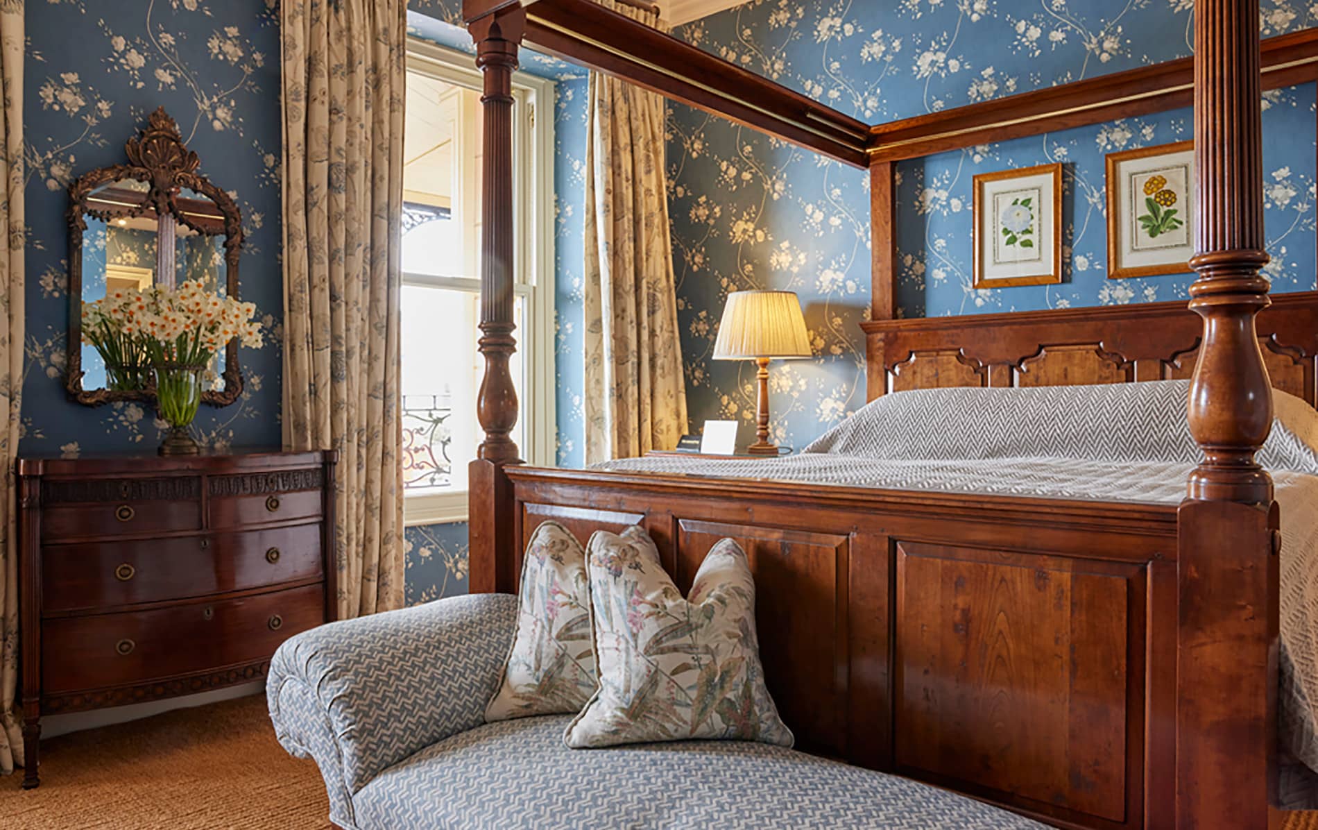 Elegant Perryville House bedroom with four-poster bed, floral wallpaper, and antique furniture in Kinsale, County Cork.