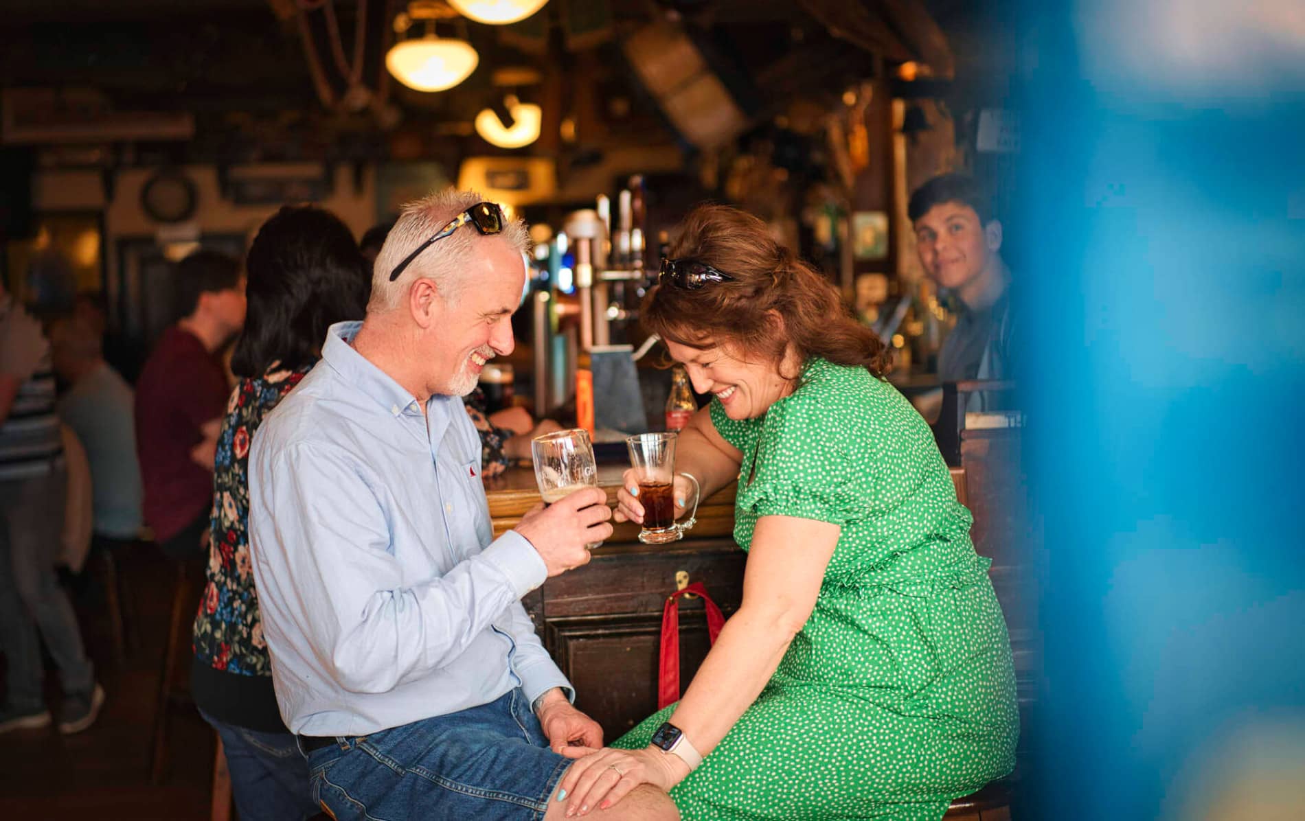Una pareja se ríe mientras toman copas en el pub de Peadar O’Donnell, un lugar animado en Derry~Londonderry, Irlanda del Norte.