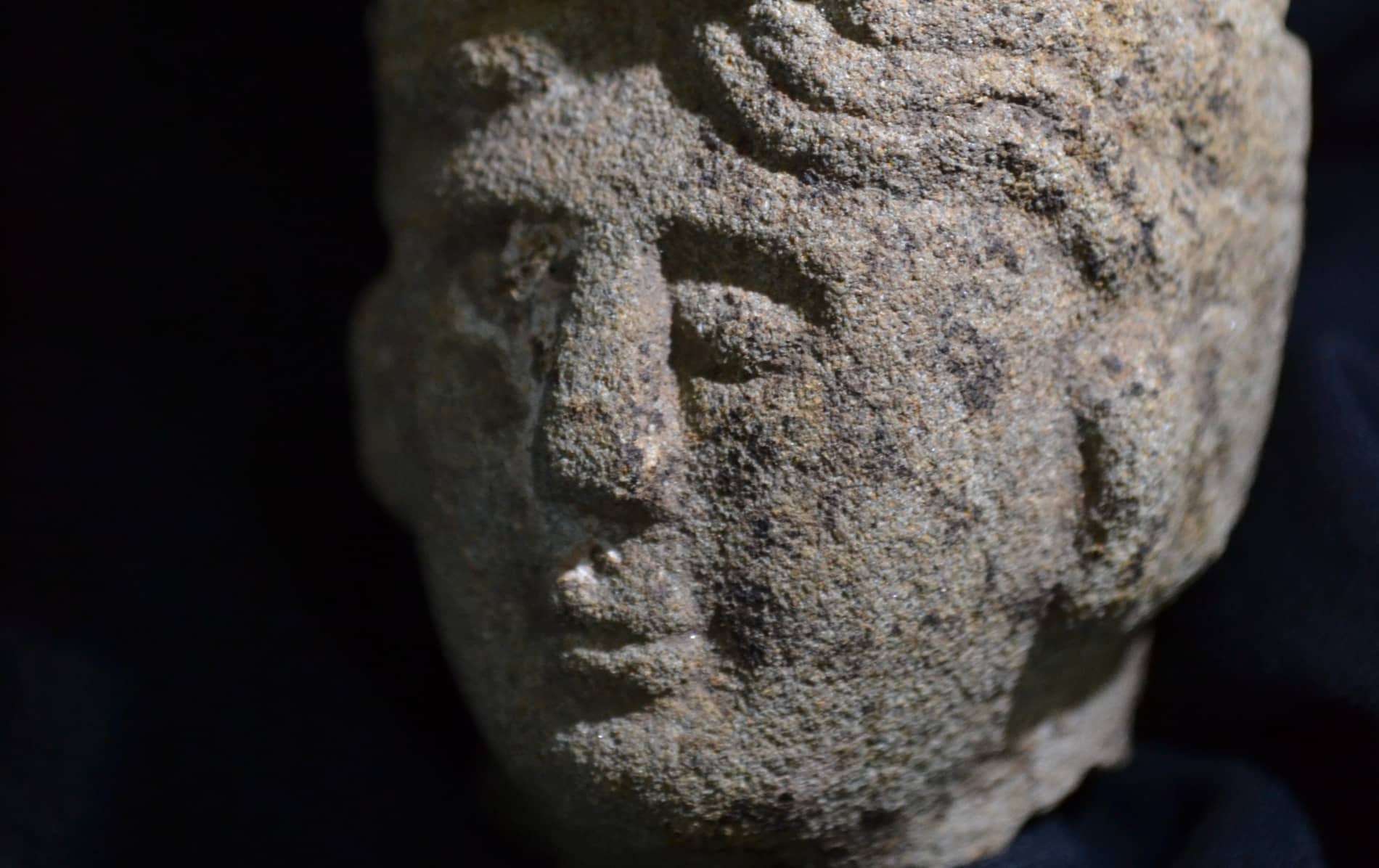 Close-up of carved stone female face representing pre-Christian goddess Brigid in Ireland.