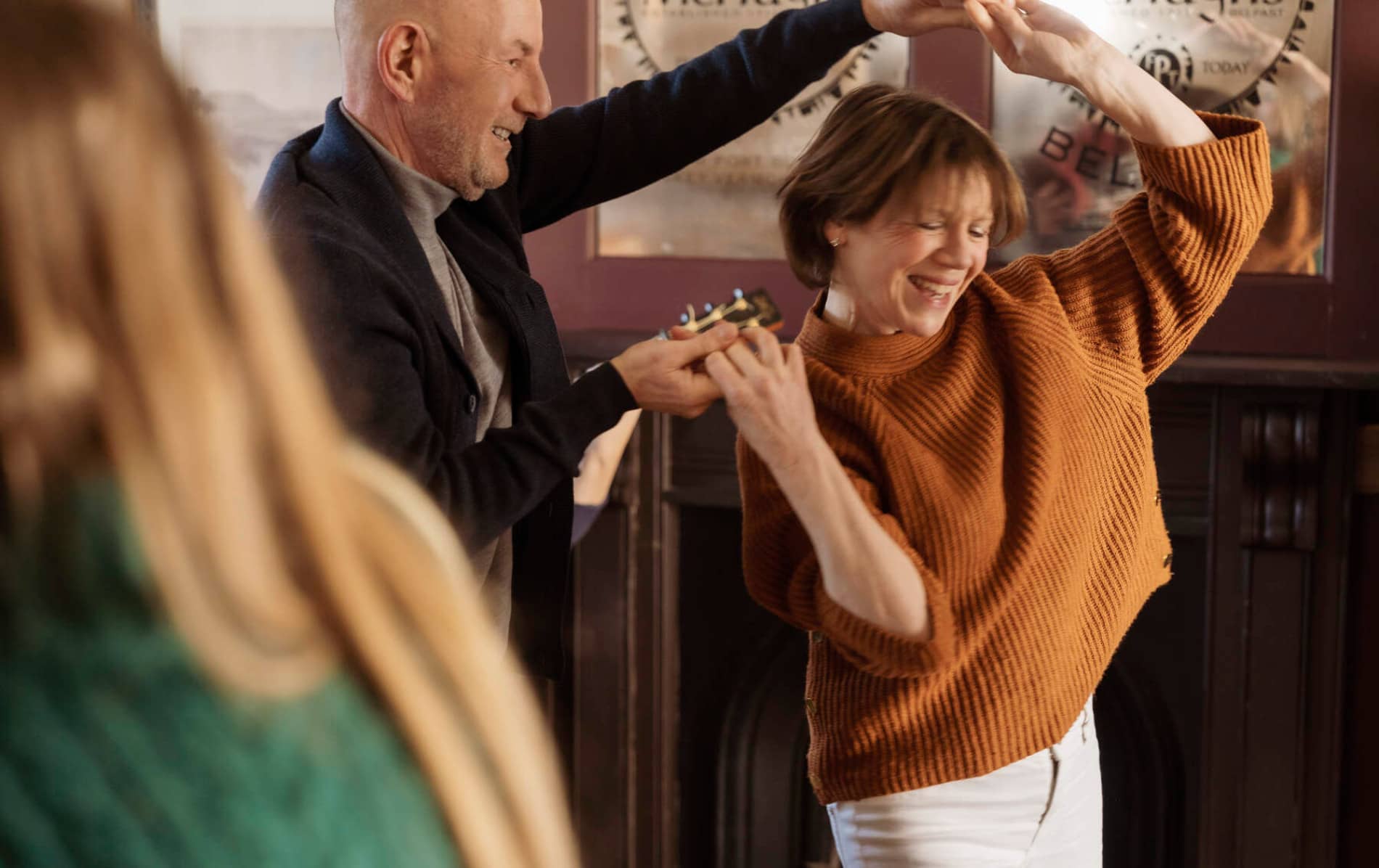 Lachend stel danst samen in een pub in Belfast tijdens een stop op het Belfast traditionele muziek pad.