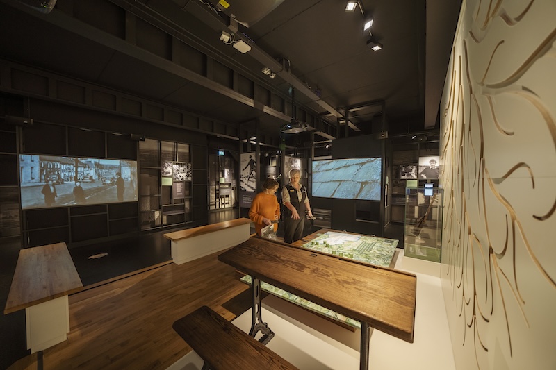 Alcuni visitatori osservano display interattivi ed esposizioni digitali all'interno del Seamus Heaney HomePlace nella contea di Londonderry.