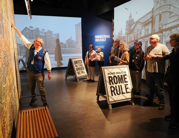 I visitatori partecipano a un'esperienza interattiva guidata all'interno di una mostra al museo di storia, nell'ambito dell'esperienza BelfastLad.