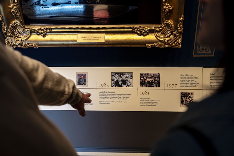 I visitatori indicano una linea temporale storica che mostra i momenti salienti all'interno del Castello di Hillsborough, nella contea di Down.