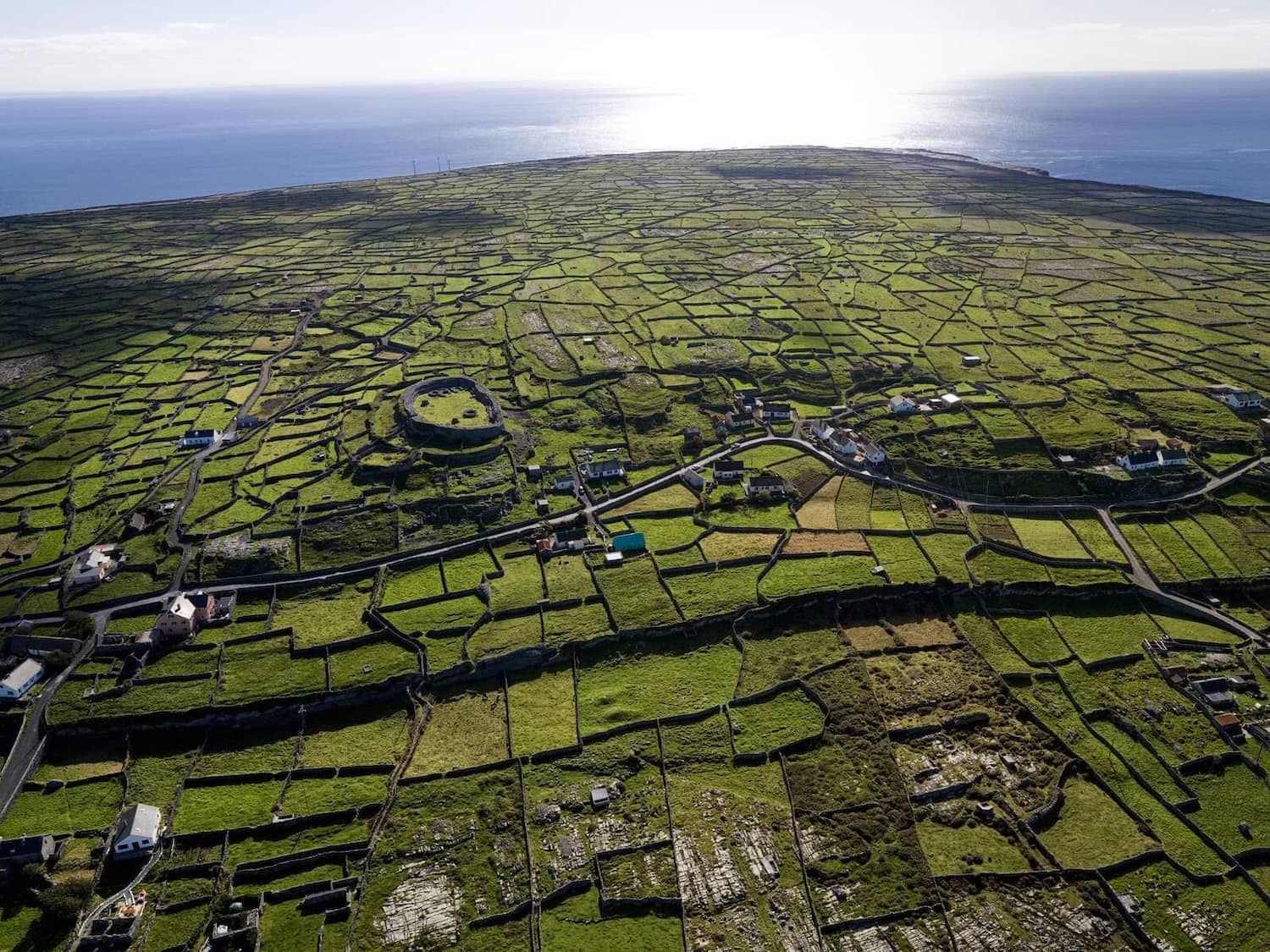Patchwork of stone-walled green fields on Inis Meáin stretching toward the Atlantic Ocean.