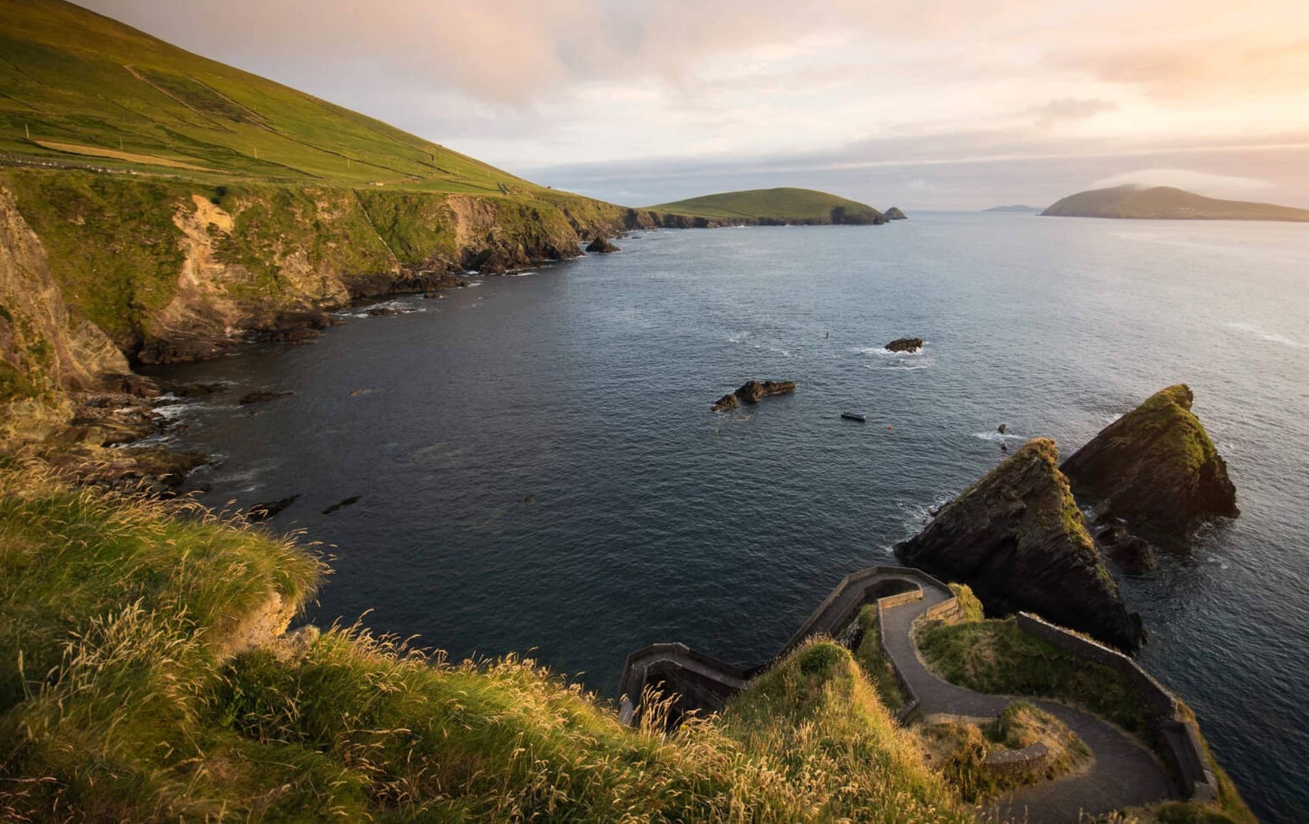 El icónico camino en zigzag del Puerto de Dunquin, Kerry, desciende dramáticamente hasta el mar con vistas a acantilados escarpados e islas rocosas.