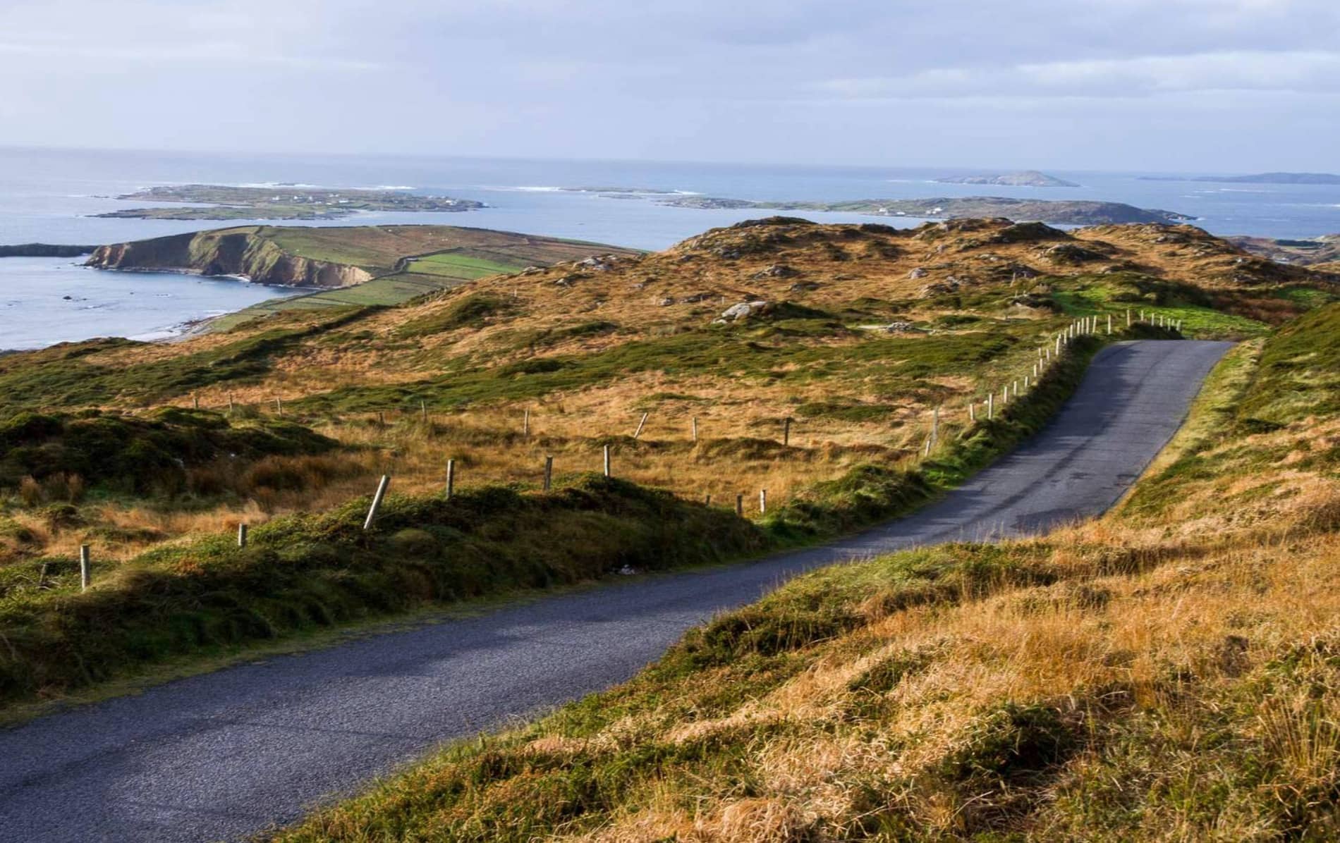 Un camino sinuoso conduce a través de las colinas ondulantes de Sky Road, Clifden, Galway, con vistas panorámicas de la costa atlántica.
