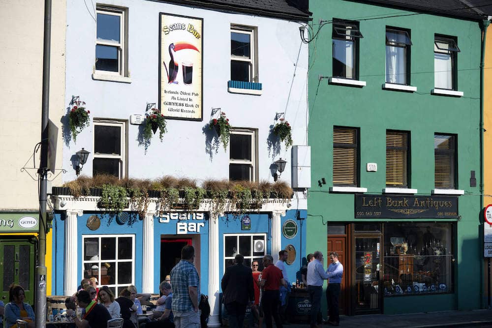 Colourful facade of Sean’s Bar in Athlone with people gathered outside on a sunny day.