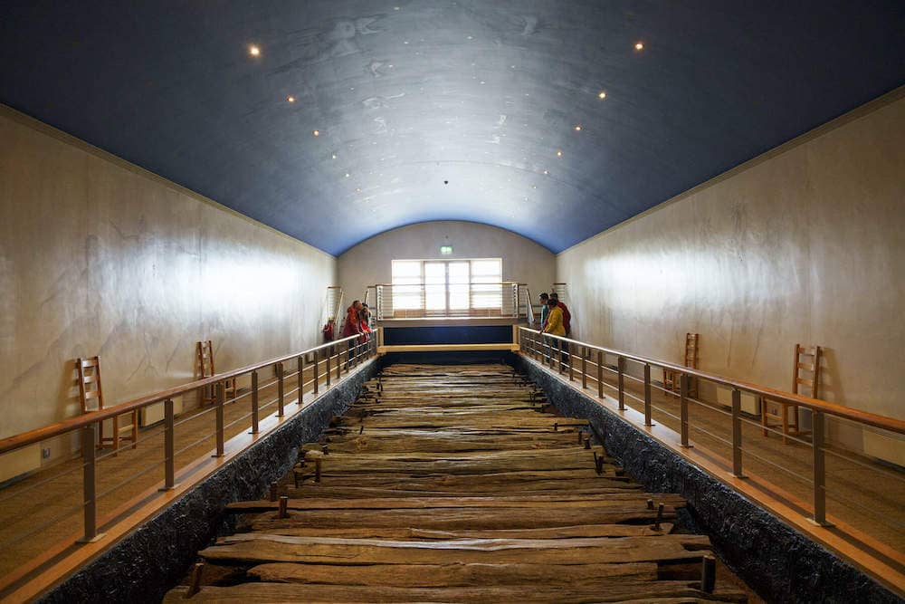 Ancient oak road preserved indoors with elevated walkways and museum lighting at Corlea Trackway.