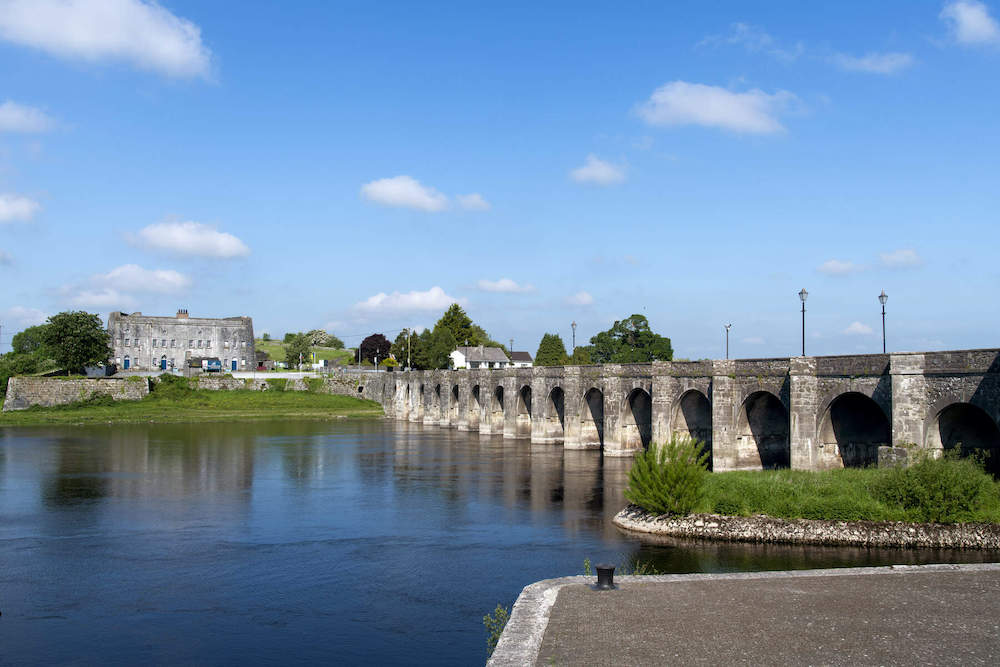 Stone arched bridge crossing the River Shannon at Shannonbridge on a bright, clear day.