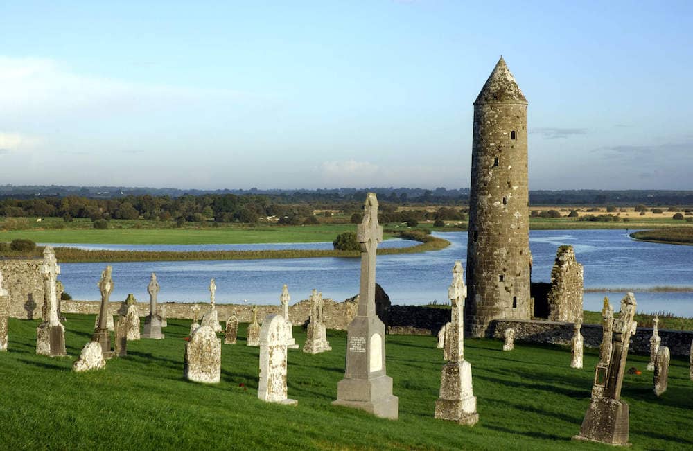 Celtic crosses and round tower at Clonmacnoise overlooking the River Shannon in County Offaly.