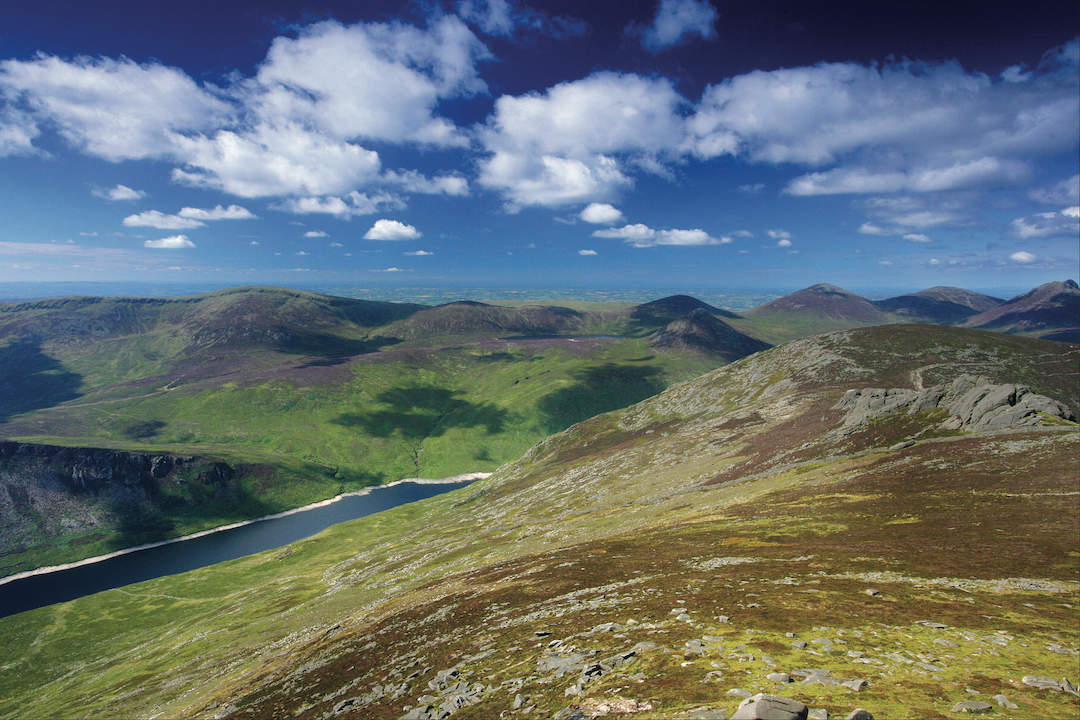 Panoramic view from Slieve Binnian over the Mourne Mountains with Ben Crom Reservoir below.