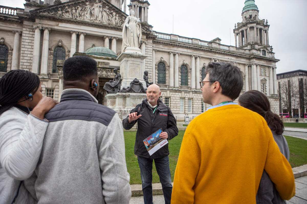 Een gids die een stadswandeling leidt voor het stadhuis van Belfast, in het centrum van Belfast.
