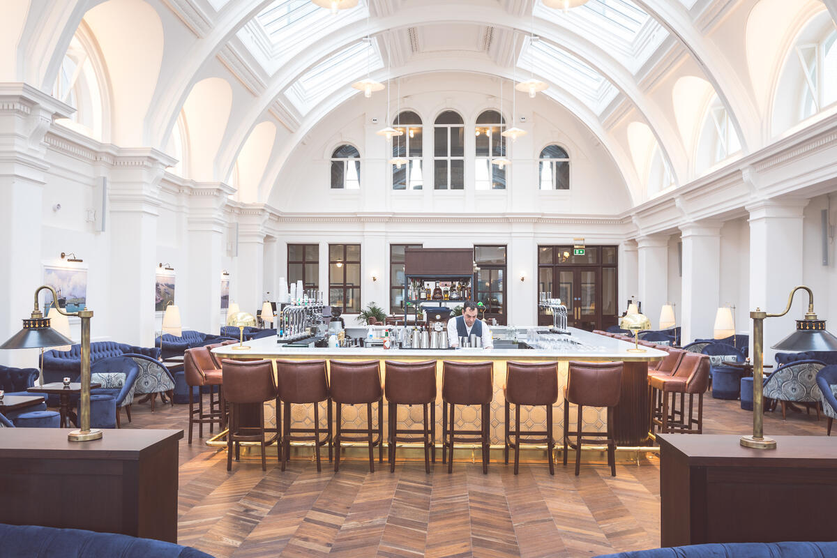 Een bar onder het gewelfde atrium in Titanic Hotel Belfast in het Titanic Quarter.