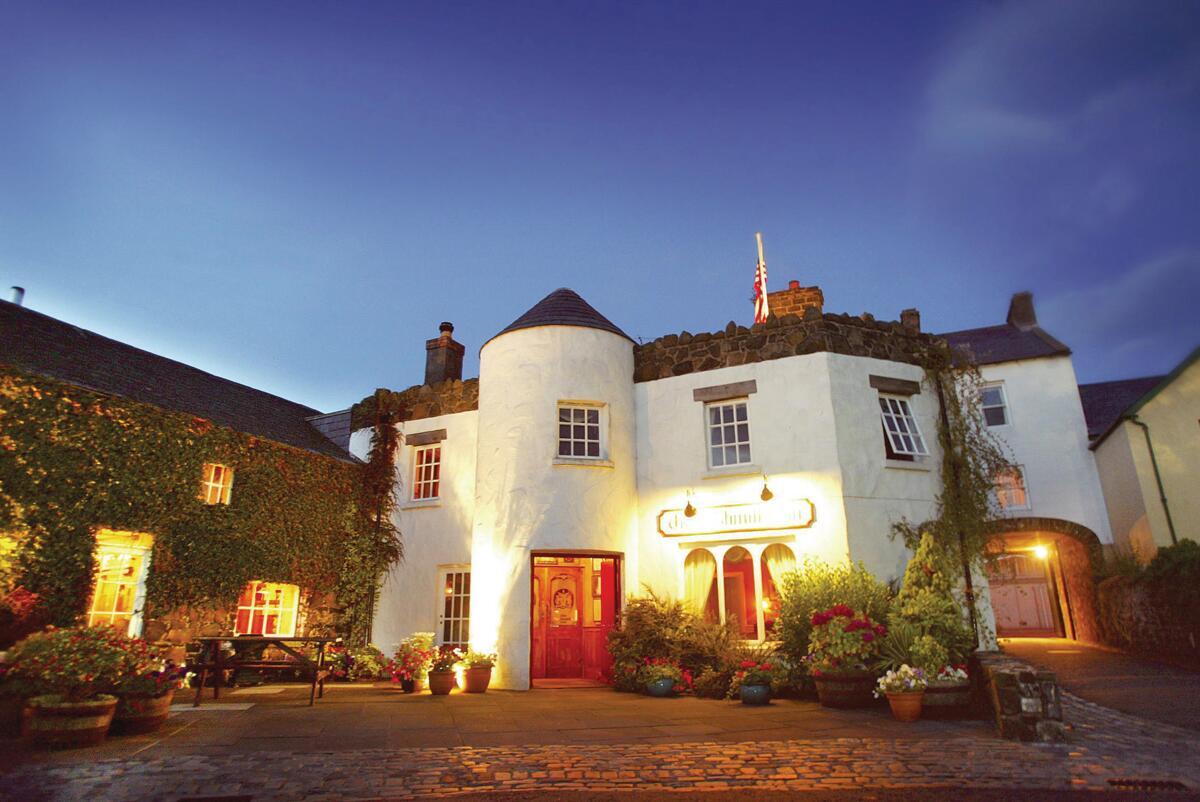 De Bushmills Inn, verlicht bij zonsondergang, in Bushmills, county Antrim.