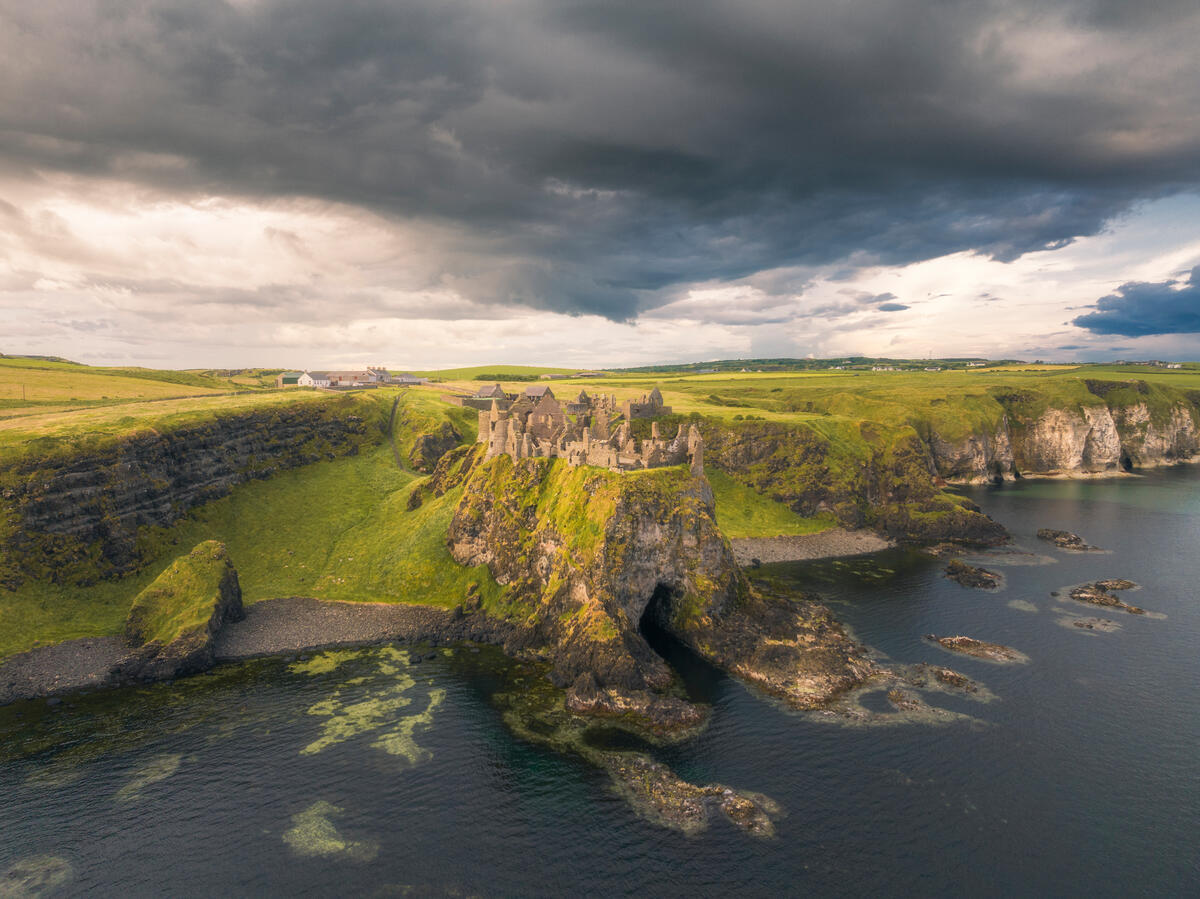 Luchtfoto van Dunluce Castle op de indrukwekkende kliffen boven de Noord-Atlantische Oceaan, county Antrim.