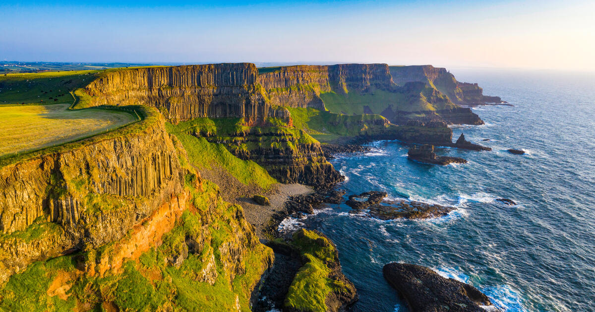Basaltkliffen aan de Causeway-kust in county Antrim, hoog boven de Atlantische Oceaan, tijdens het gouden uurtje.
