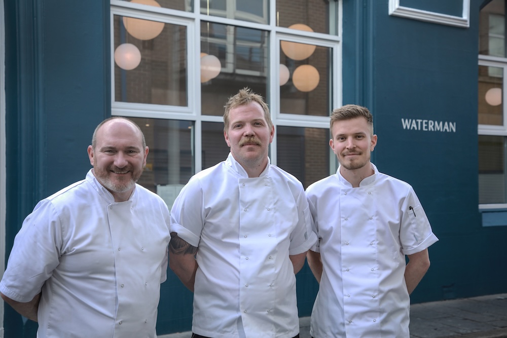Koks die voor restaurant Waterman in Belfast staan.