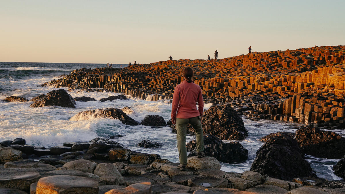 Iemand die tussen de basaltkolommen van de Giant's Causeway in county Antrim staat.