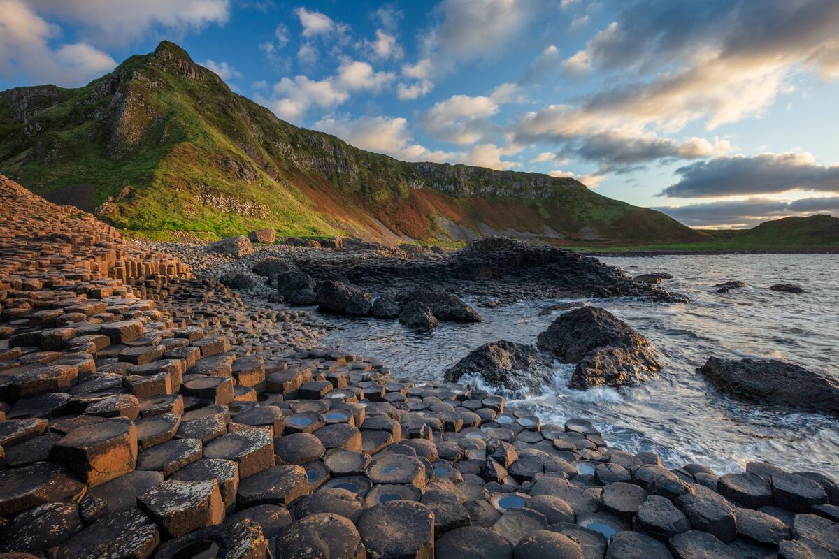 Basaltkolommen bij de Giant's Causeway met daarachter hoge kliffen, county Antrim.