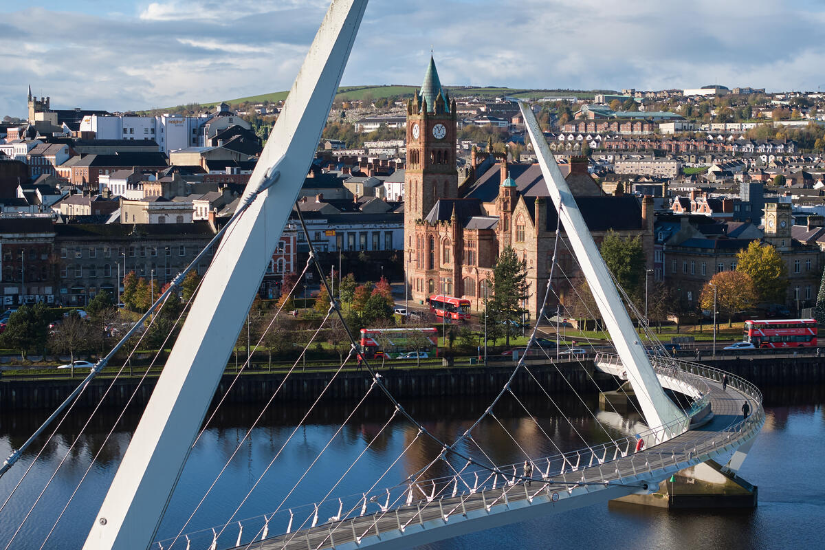 De skyline van Derry~Londonderry, omlijst door de Peace Bridge die de rivier de Foyle overspant.