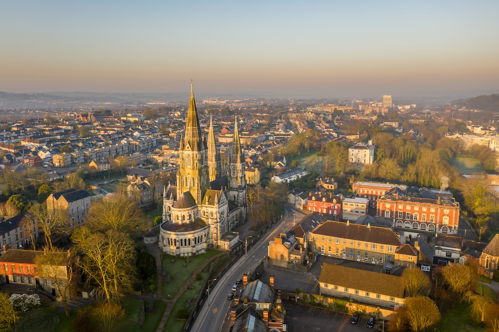 Aerial view of St Fin Barre’s Cathedral and Cork city at sunset.