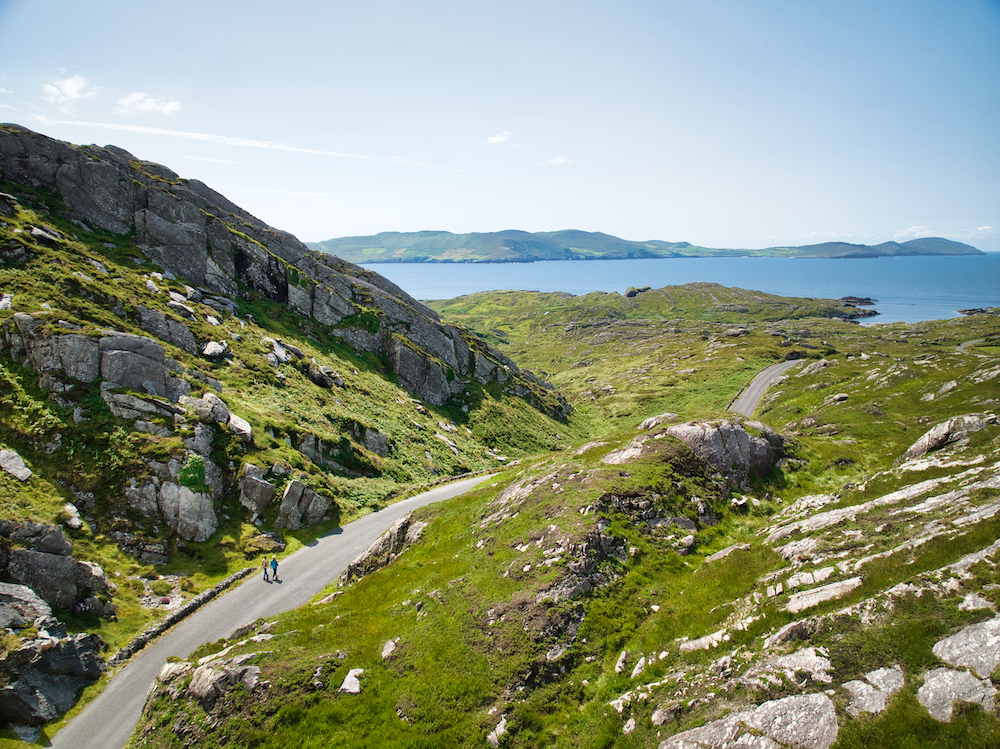 Narrow coastal road winding through rocky hills on the Beara Peninsula with views across the Atlantic.