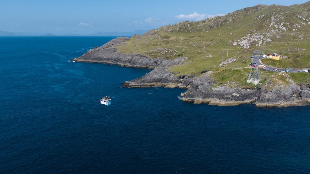 Dursey Island cable car station on the Beara Peninsula with a boat on the Atlantic below.