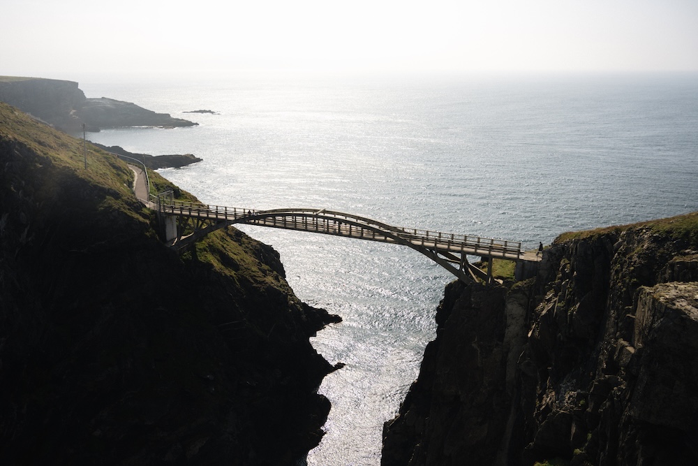 Mizen Head Footbridge spanning a deep sea gorge on Ireland’s rugged southwest coast, with the Atlantic Ocean beyond.