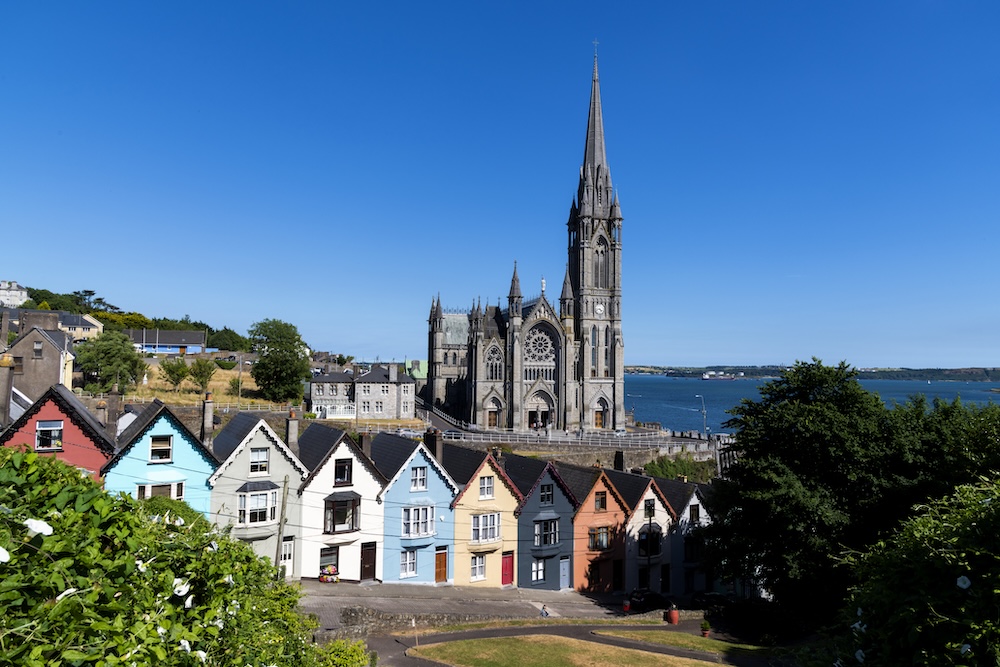 St Colman’s Cathedral overlooking colourful houses and Cork Harbour in Cobh, County Cork.
