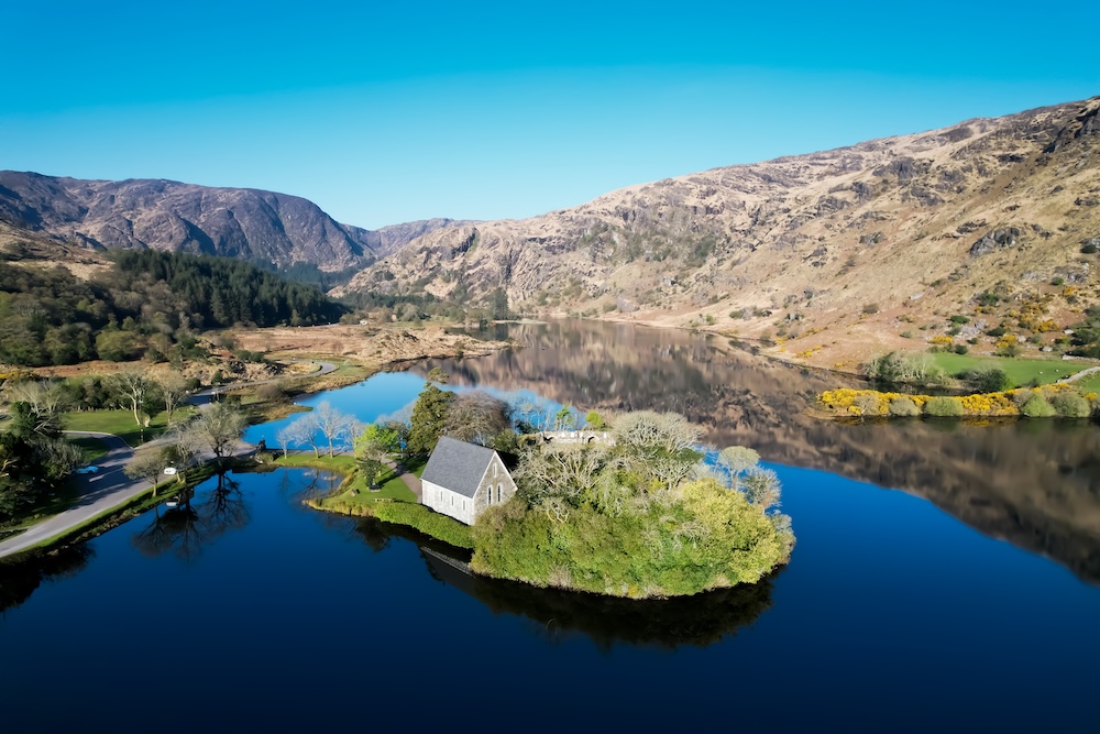 St Finbarr’s Oratory on a small island in Gougane Barra lake surrounded by mountains.