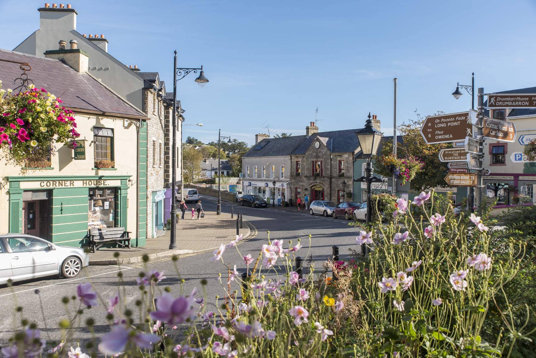 Charmante straat in Ardara, county Donegal, met hangende bloembakken en traditionele Ierse winkelpuien.
