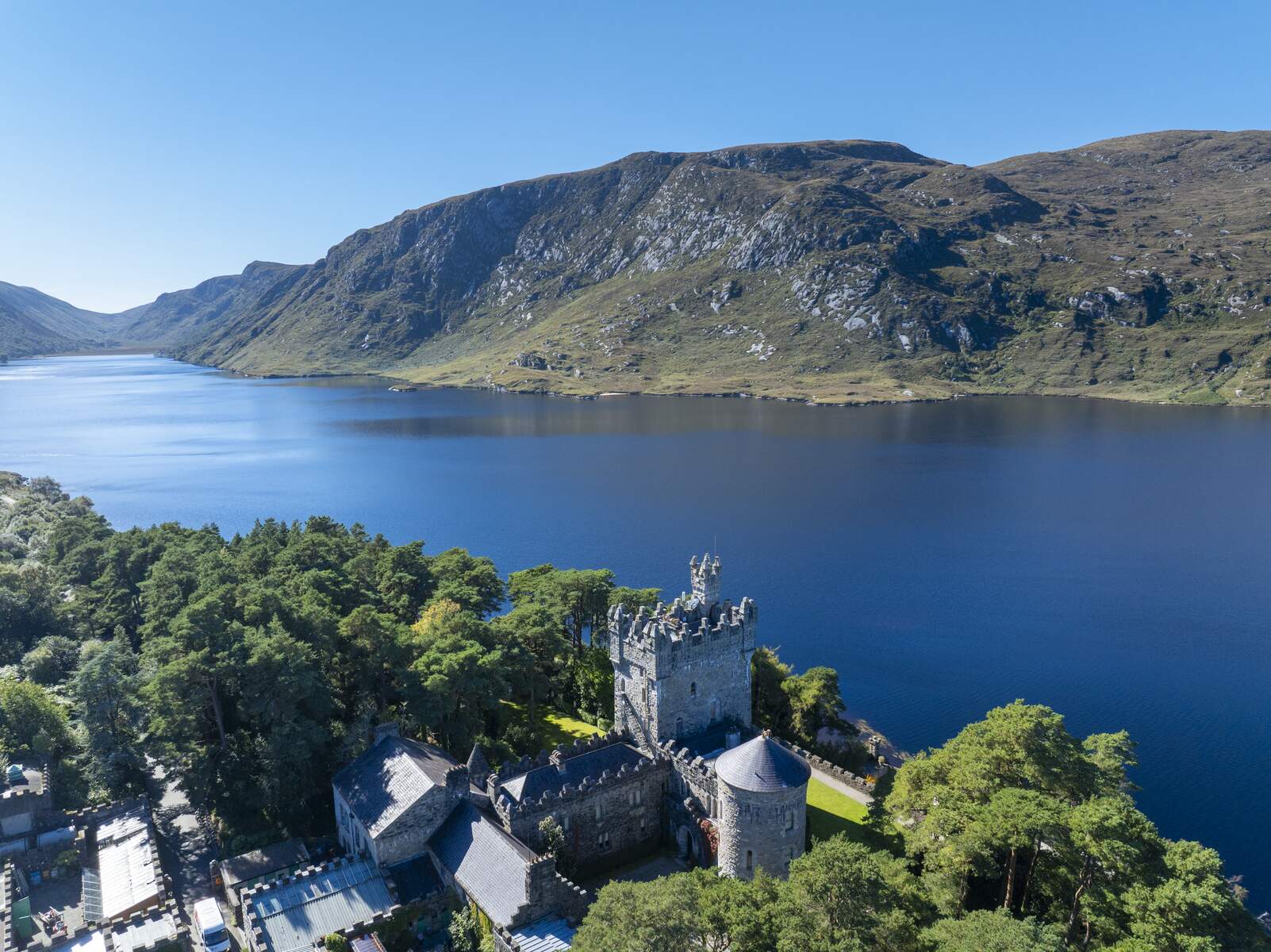 Glenveagh Castle bij Lough Veagh, omgeven door bomen en bergen in GlenveaghNational Park, county Donegal.