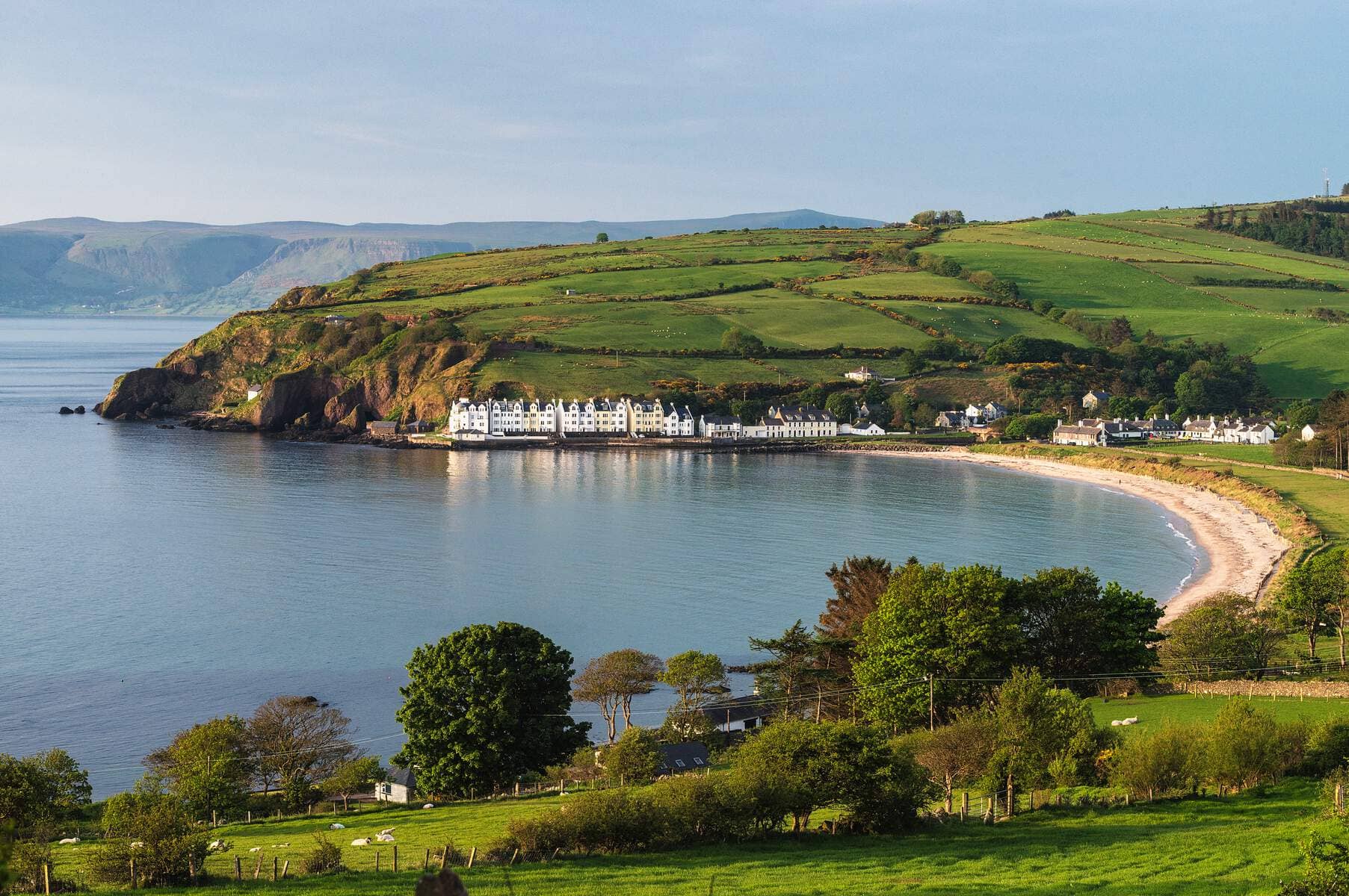 De kustplaats Cushendun en groene heuvels gezien vanaf Torr Head Road in county Antrim.